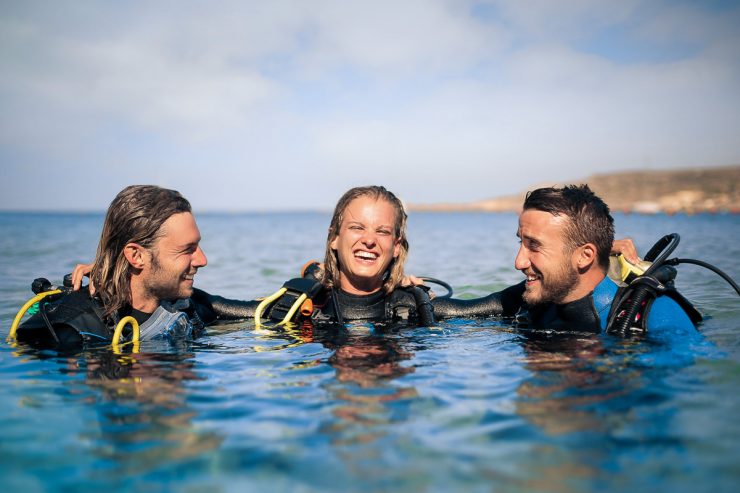 scuba divers enjoying their excursion in the sea
